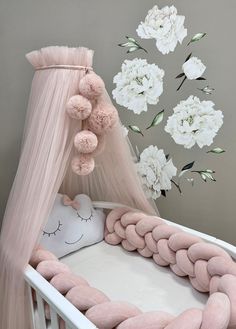 a baby crib with pink and white flowers in the background