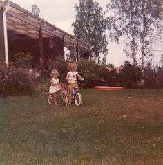 two children on bikes in front of a house