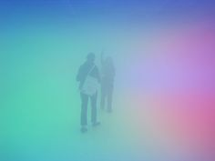 two people standing in the fog with their arms up