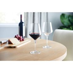 two wine glasses sitting on top of a wooden table