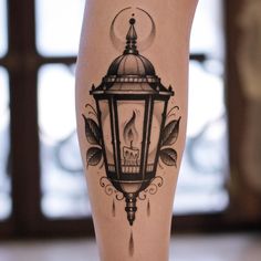 a tattoo on the leg of a woman with a candle and leaves around her legs