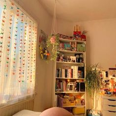 a living room filled with furniture next to a window covered in colorful curtained drapes