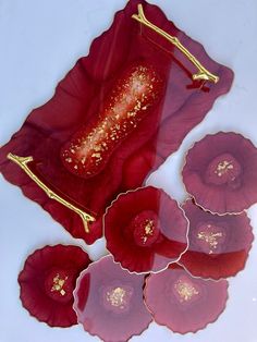 red flowers with gold flecks are on a white surface