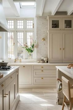 a large kitchen with white cabinets and marble counter tops