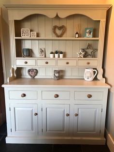 a white china cabinet with drawers and shelves