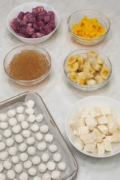 several bowls with different types of food in them on a white counter top next to each other