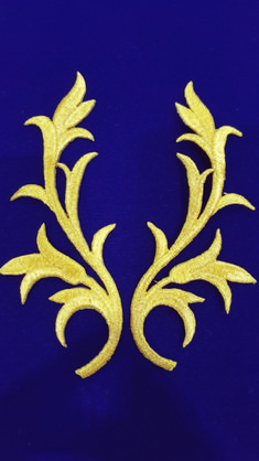 two gold colored flowers are on a blue background, one is in the shape of a flower