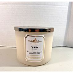 the vanilla bean candle is next to a white wall