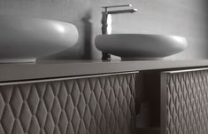 two white sinks sitting on top of a wooden counter