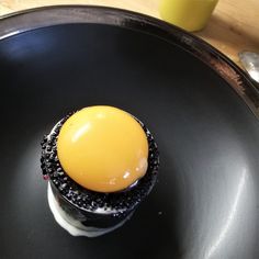 an egg is sitting on top of a black plate