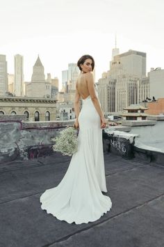 a woman standing on top of a roof holding a bouquet