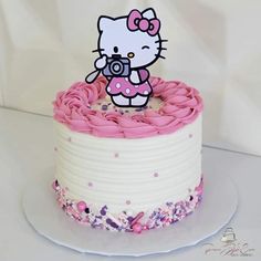 a hello kitty cake with pink icing and sprinkles on the top