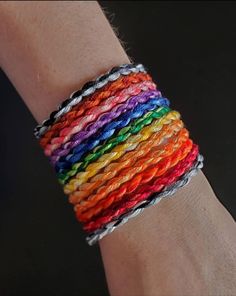 a person wearing a rainbow colored bracelet on their arm