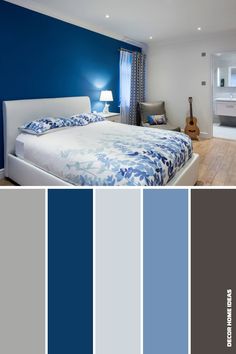 a bedroom with blue and gray walls, white bedding, and furniture in it