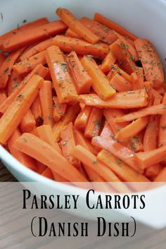 a white bowl filled with sliced carrots on top of a wooden table and the words parsley carrots danish