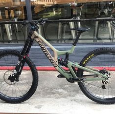 a mountain bike parked in front of a building with its wheels still on the ground