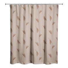 a beige shower curtain with brown feathers on the outside and tan curtains in the inside