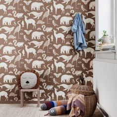 an animal themed wallpaper in a child's room with a chair and toy