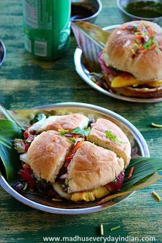 two plates filled with sandwiches on top of a wooden table