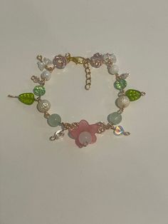 Green,pink, and clear fairy core bracelet. Spring Rose Gold Flower Bracelets, Spring Rose Gold Flower Bracelet, Bracelet Ideas Coquette, Dainty Flower Bracelets For Party, Fairy Core Bracelets, Pink Beaded Flower-shaped Jewelry, Cute Flower Jewelry For Party, Cute Spring Bracelet Jewelry, Cute Flower-shaped Party Jewelry