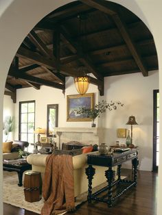 a living room filled with furniture and a fire place in the middle of a room