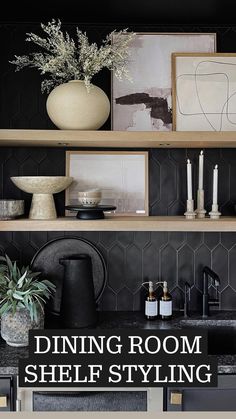 a kitchen with black and white decor on the shelf above the sink, potted plant in front of it