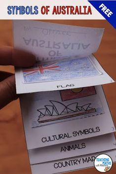 a person holding up some cards with the words symbols of australia on them and an australian flag