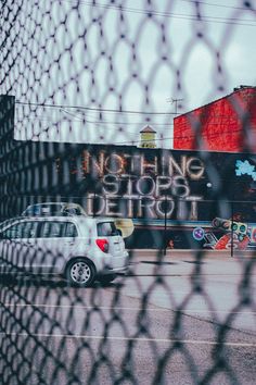 a car parked in front of a building with graffiti on it