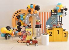 a mickey mouse birthday party with balloons and decorations