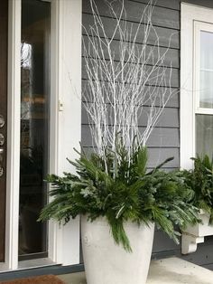 a large white planter sitting on the side of a house next to a door