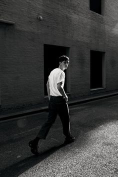 a man walking down the street in front of a building