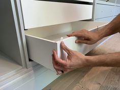 a man is opening the drawers in his kitchen