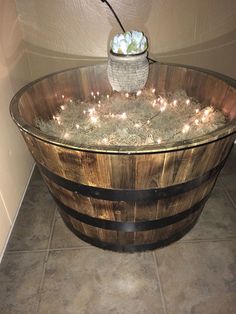 a wooden barrel filled with plants and lights