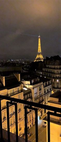 the eiffel tower is lit up at night from an apartment balcony in paris