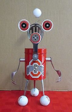 a red tin can robot with eyes and two golf balls