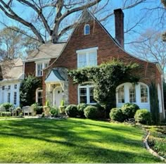 a large brick house surrounded by trees and grass