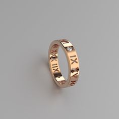 a gold ring with roman numerals on the side and diamond in the middle