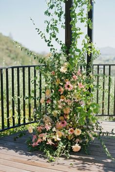 an arrangement of flowers on a wooden deck