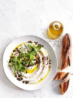 a white plate topped with food next to bread