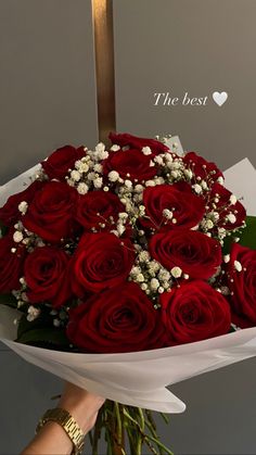 a bouquet of red roses in front of a cross