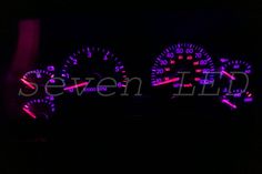 the speedometers are lit up in the dark with purple lights and numbers on them