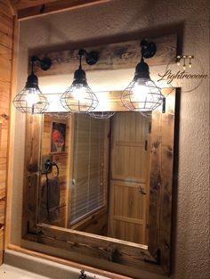 a bathroom vanity with three lights and a mirror