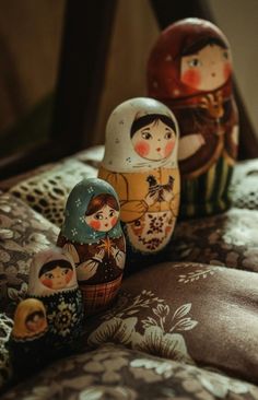 three nesting dolls sitting on top of a bed