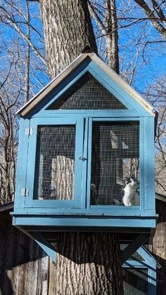 a tree house that is built into the side of a tree with two cats in it