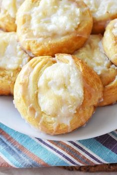 a white plate topped with frosted pastries on top of a striped table cloth