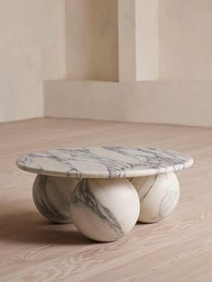 three marble balls sitting on top of each other in the middle of a room with wood flooring