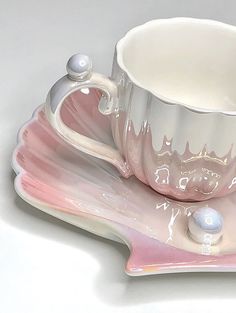 a pink and white coffee cup on a saucer