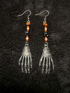 Embrace the spooky season with these Halloween dangling earrings that capture the essence of the holiday perfectly. Adorned with intricately designed skulls, pumpkins, cats, and bats, each earring tells a whimsical tale of Halloween folklore. The lightweight yet eye-catching design ensures comfort while making a bold statement. Whether you're dressing up for a costume party or simply adding a touch of Halloween spirit to your ensemble, these earrings are the ideal accessory. Let these festive earrings be your playful companion throughout the Halloween season, adding a touch of macabre charm to any outfit. Celebrate the magic of Halloween with these unique, themed earrings that are sure to turn heads and spark conversations wherever you go. Earrings are approximately 2.5" in total length. T Spooky Halloween Jewelry For Costume Party, Spooky Halloween Costume Party Jewelry, Halloween Dangle Metal Earrings, Witchy Metal Earrings For Halloween, Witchy Metal Halloween Earrings, Metal Dangle Earrings For Halloween, Dangle Halloween Earrings, Spooky Pierced Earrings For Halloween, Halloween Metal Drop Earrings