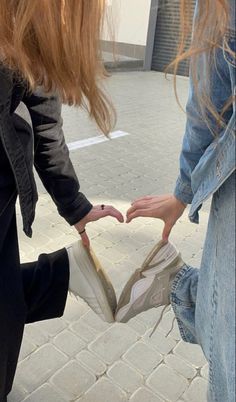 two girls are holding onto each other's shoes