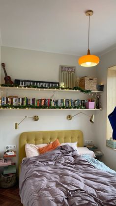 a bed sitting in a bedroom next to a wall mounted shelf with books on it